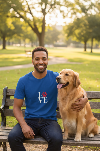 Man sitting in a park with a golden retriever wearing the Love Dogs blue t-shirt